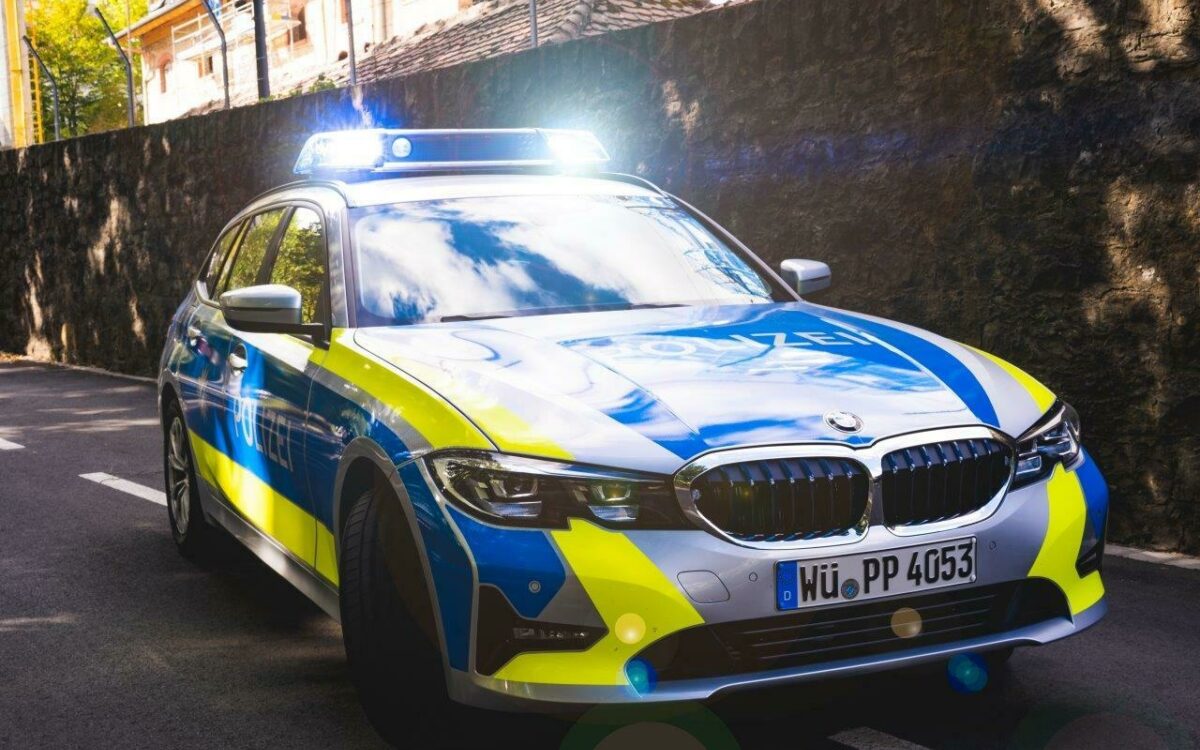 Polizei im Einsatz Das Polizeiauto steht mit Blaulicht am Straßenrand Polizei im Einsatz Das Polizeiauto steht mit Blaulicht am Straßenrand